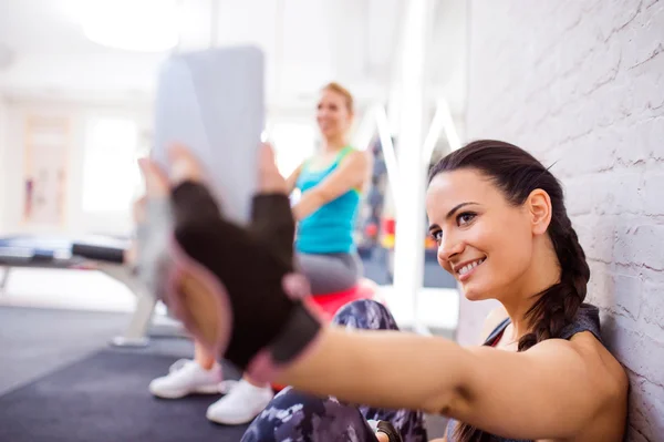 Mujer en el gimnasio sosteniendo el teléfono inteligente, tomando selfie —  Fotos de Stock