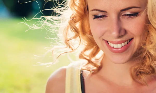 Blond woman, curly hair in green nature. Sunny summer — Stok fotoğraf