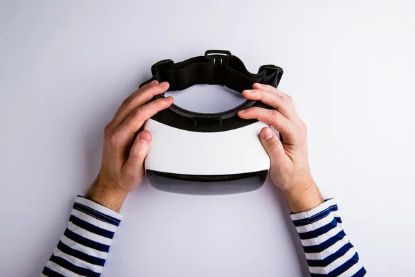 Mãos de homem segurando óculos de realidade virtual. Depósito plano — Fotografia de Stock