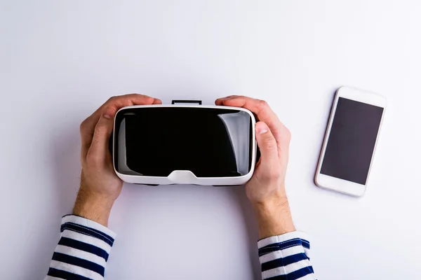 Mãos de homem segurando óculos de realidade virtual e smartphone — Fotografia de Stock
