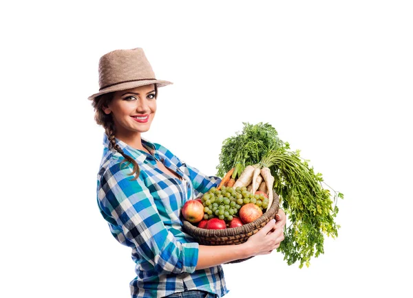 Woman, checked shirt holding basket with fruit and vegetables — Stock fotografie