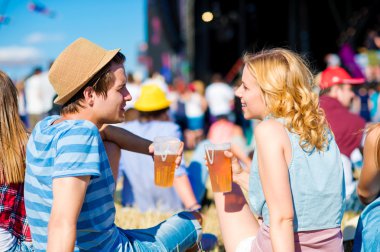 Young couple with beer at summer music festival