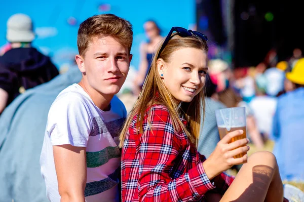 Young couple with beer at summer music festival — Stock Photo, Image