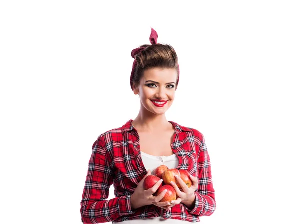 Woman, pin-up hairstyle holding armful of apples. Autumn harve — Φωτογραφία Αρχείου