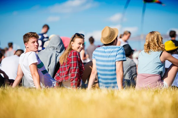 Nastolatki na letnim festiwalu muzycznym, siedząc na trawie — Zdjęcie stockowe