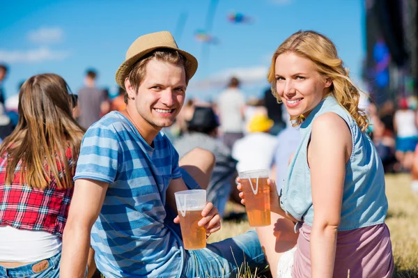 Young couple with beer at summer music festival — Stok fotoğraf