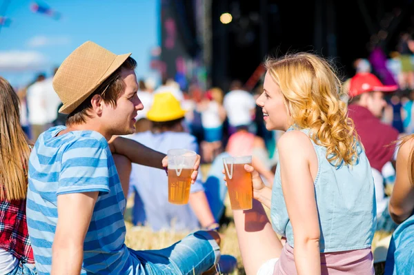Young couple with beer at summer music festival — Zdjęcie stockowe