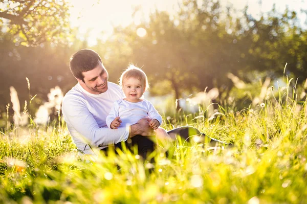 Père tenant son petit fils dans la nature — Photo