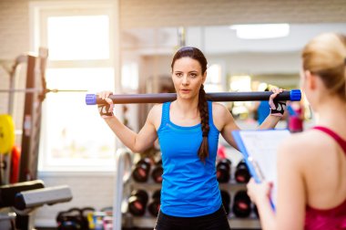 Spor salonunda antrenör ile egzersiz kadın