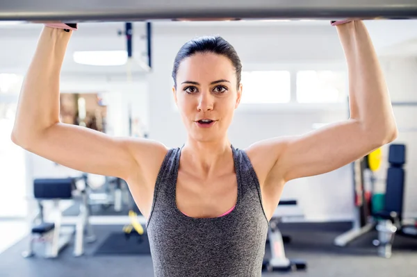 Kadın kol egzersizleri yapıyor spor salonunda — Stok fotoğraf