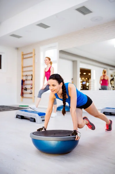 Two women in gym doing exercises — Stock Photo, Image