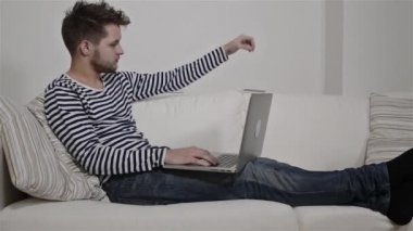 kanepede dizüstü bilgisayarda çalışan adam