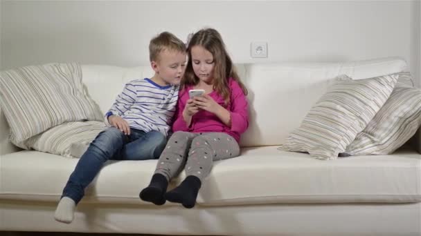 Niños en casa jugando con smartphone — Vídeos de Stock