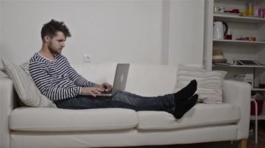 Genç adam kanepede oturan laptop çalışma