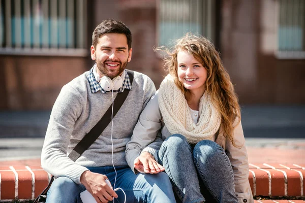 Pareja joven enamorada en la ciudad sentada — Foto de Stock