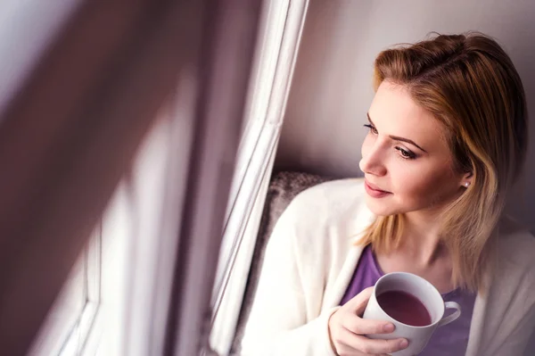 Woman on window with tea — Stock Photo, Image