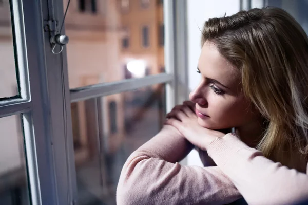 Frau sitzt auf Fensterbank — Stockfoto