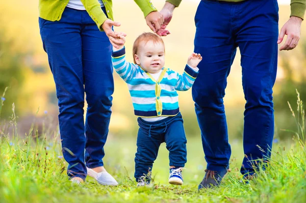 Padres con hijo dando los primeros pasos — Foto de Stock