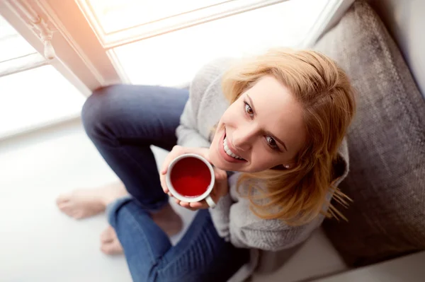 Mujer en alféizar de ventana con taza de té —  Fotos de Stock