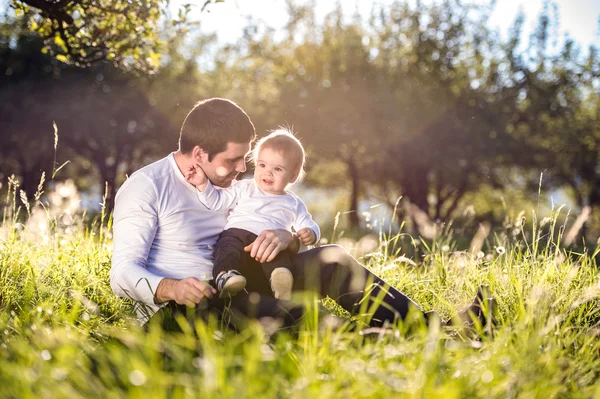 Pais com filho pequeno na grama — Fotografia de Stock