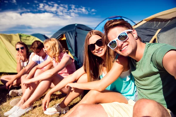 Teenagers sitting in front of tents — Stock Photo, Image