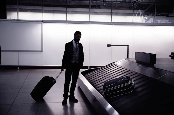 Businessman with luggage at airport — Stock Photo, Image