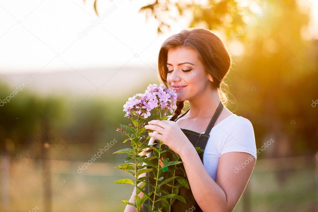 Young gardener smelling flowers