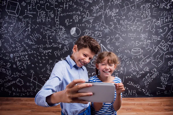 Junge und Mädchen machen Selfie an der Tafel — Stockfoto