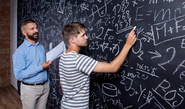 Teacher and student at blackboard — Stock Photo, Image