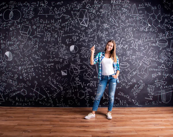 Student aan het grote krijtbord met wiskundige symbolen — Stockfoto