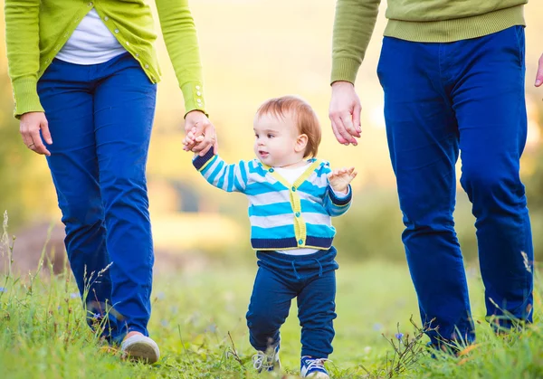 Padres con hijo dando los primeros pasos — Foto de Stock