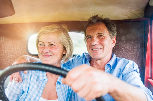 senior couple inside pickup truck