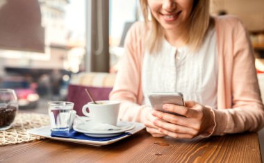 Tanınmayan smartphone kafede kahve içme kadınla