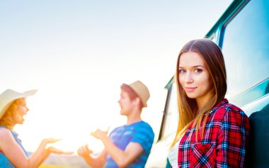 Kamp aracına yeşil güneşli doğa ile genç frieds