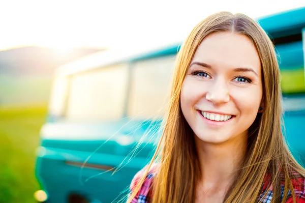 Teenage girl smiling against green campervan outside in nature — Stock Photo, Image