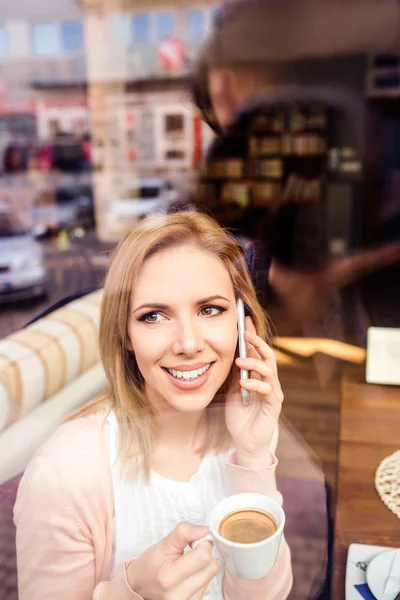 Mujer en la cafetería bebiendo café, haciendo una llamada telefónica —  Fotos de Stock