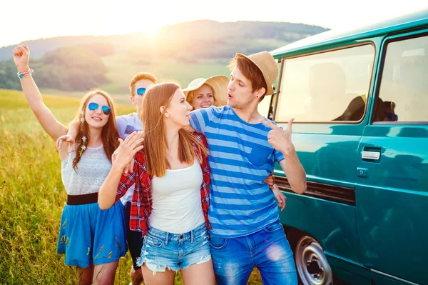 Frieds jóvenes con autocaravana, naturaleza verde y cielo azul — Foto de Stock