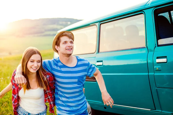 Teenage couple in love outside in nature, green campervan — Stock Photo, Image