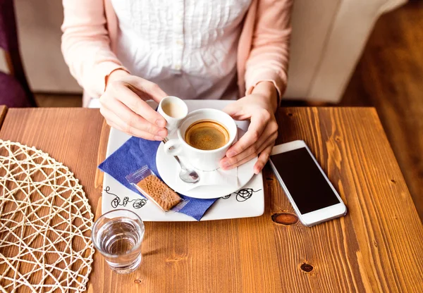 Unrecognizable woman in cafe drinking coffee, pouring cream in — Stock Photo, Image