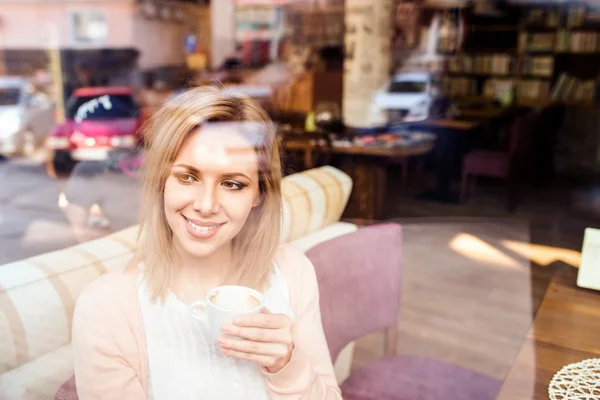 Donna in caffè bere caffè, riflesso di strada in finestra — Foto Stock