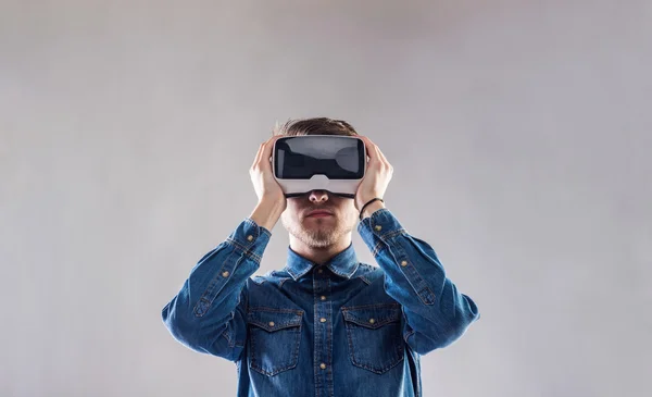 Hombre con gafas de realidad virtual. Tiro de estudio, fondo gris — Foto de Stock