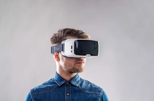 Az ember virtuális valóság szemüveget visel. Stúdió lövés, szürke backgroun — Stock Fotó