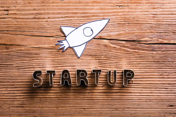 Office desk with start up sign and paper rocket. — Stock Photo, Image