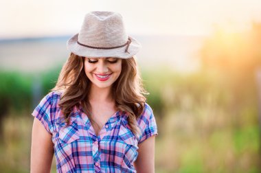 Bahçıvan ekose desenli gömlek ve şapka, yeşil güneşli doğa