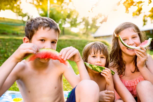 Barn äter vattenmelon i trädgården — Stockfoto