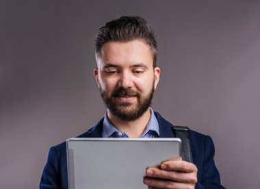 Tablet, stüdyo çekim, gri arka plan ile Hipster işadamı
