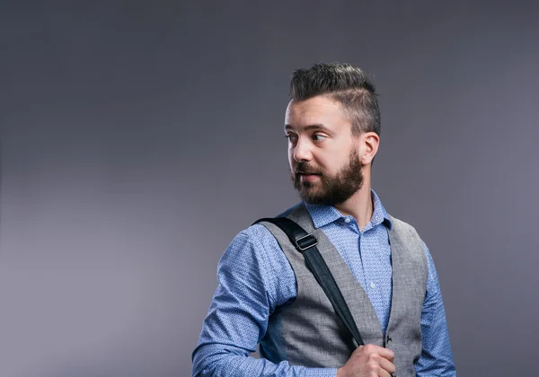 Hipster obchodník na modré košili, snímek studia, šedé pozadí — Stock fotografie