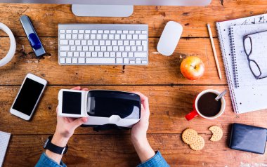 Sanal gerçeklik goggl tutarak Ofis Masası çalışma iş adamı