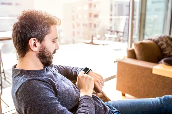 Man working from home using smart watch, living room — Stock Photo, Image
