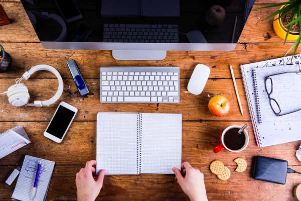 Persona de negocios que trabaja en el escritorio de la oficina sosteniendo un cuaderno — Foto de Stock